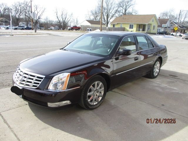 Black Cadillac sedan parked on a sunny street, showing front and side view.