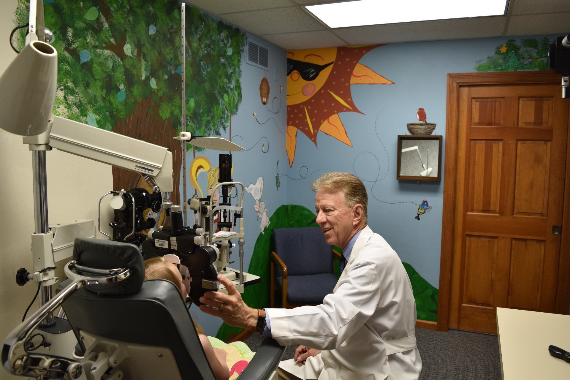 Vision Exam — A Kid smiling while sitting on chair at the ophthalmologist in Belleville, IL