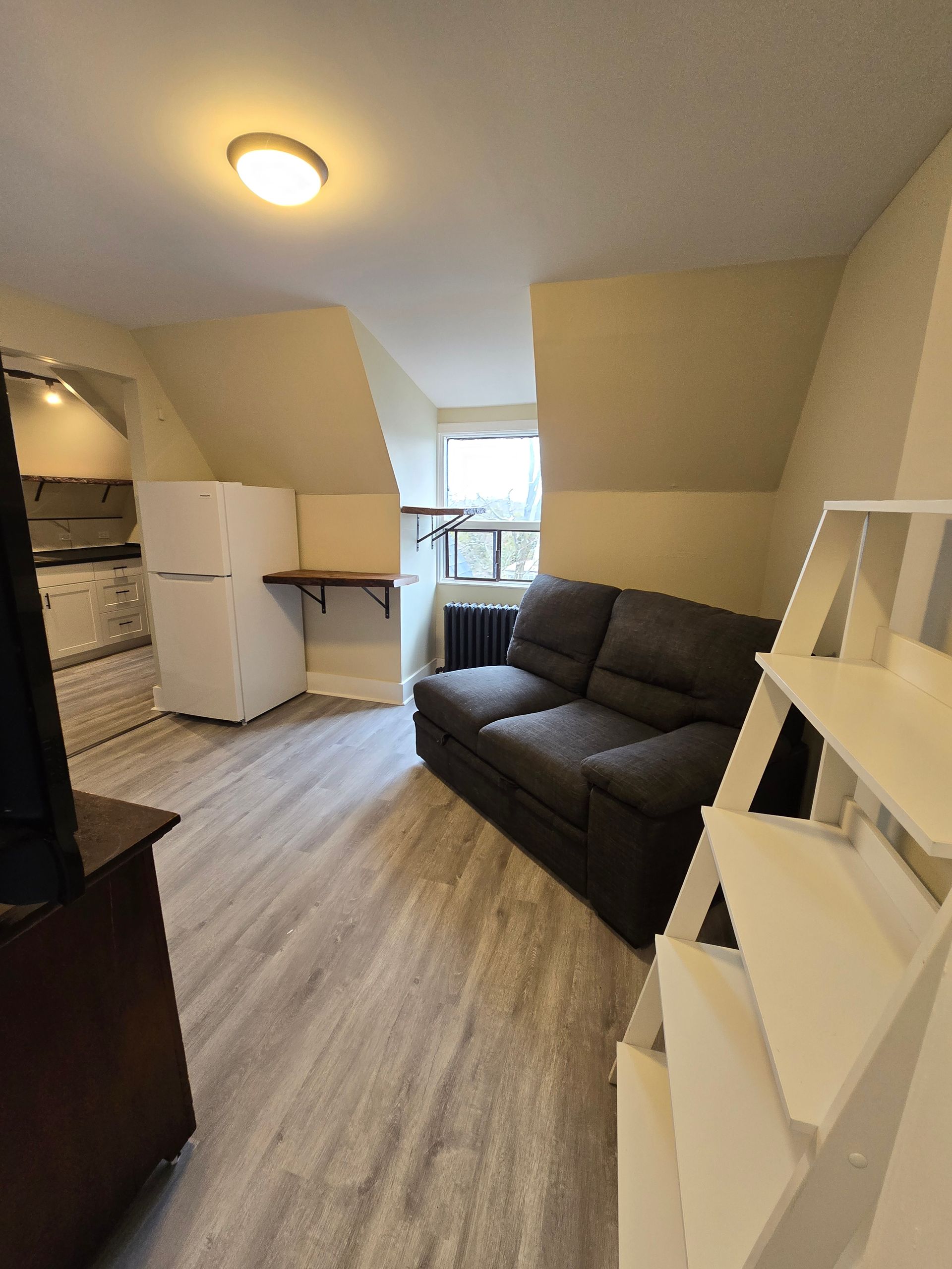 A living room with a couch and a refrigerator