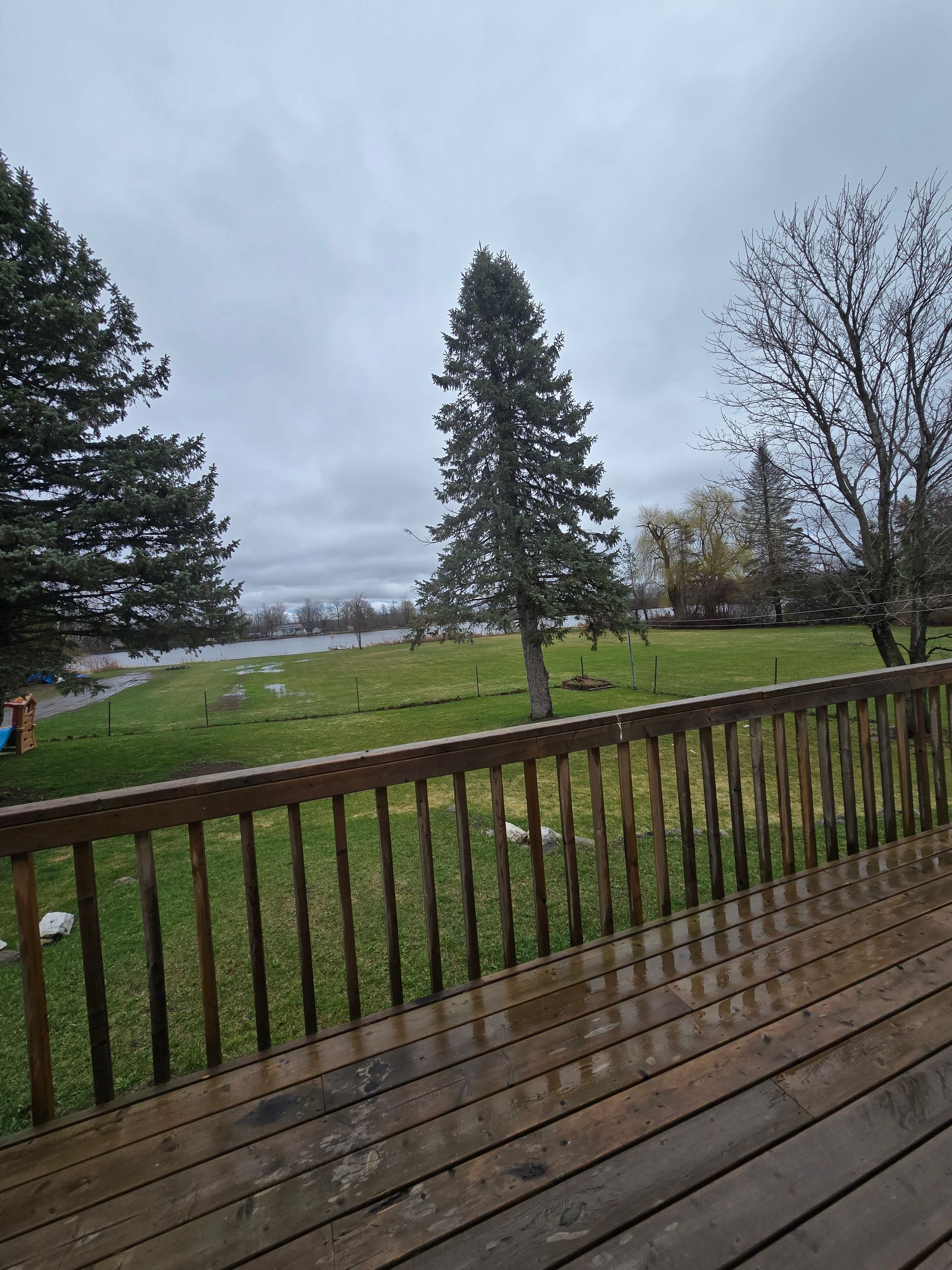 A view of a field from a deck on a cloudy day.