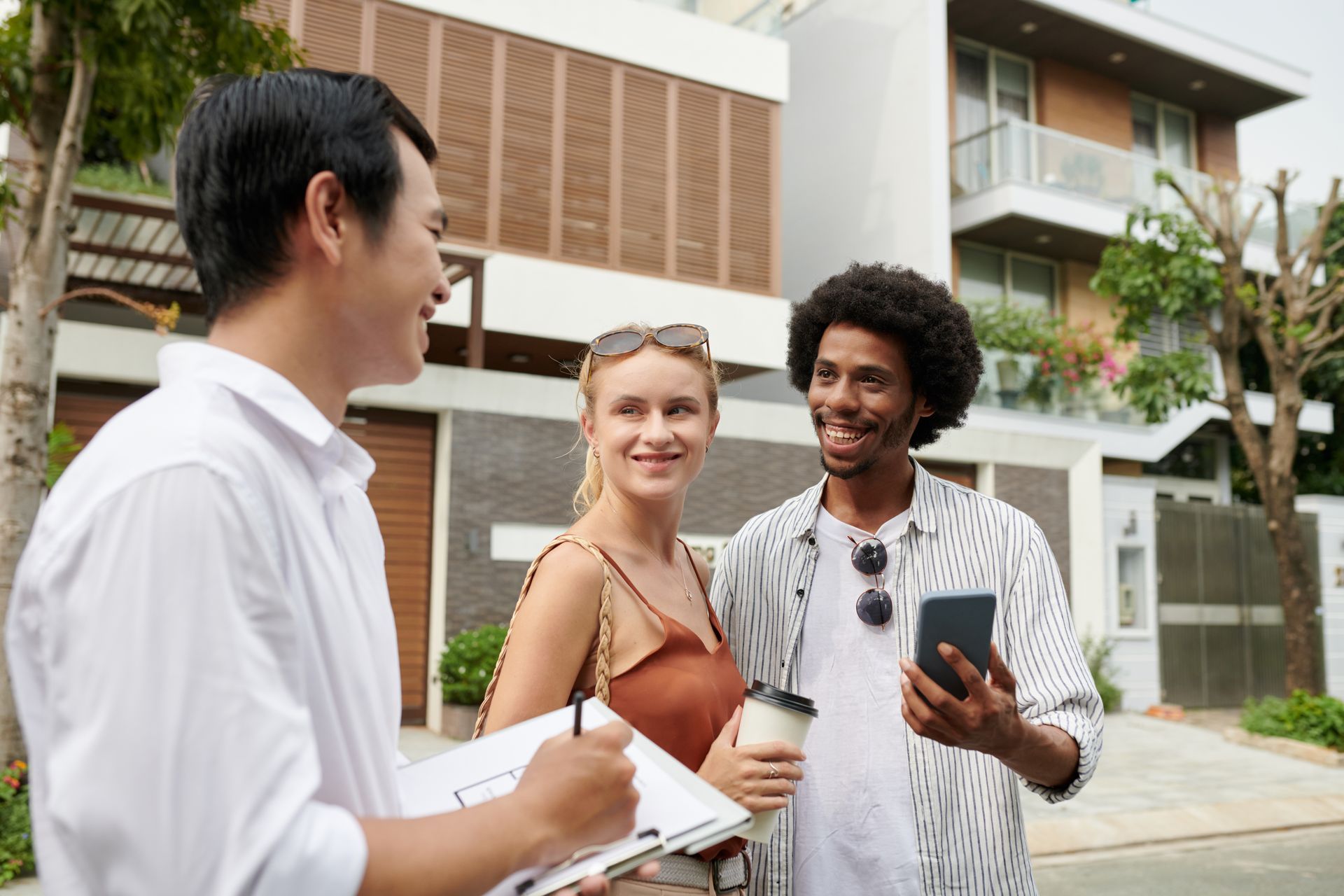 A man is talking to a woman and a man is holding a cell phone.