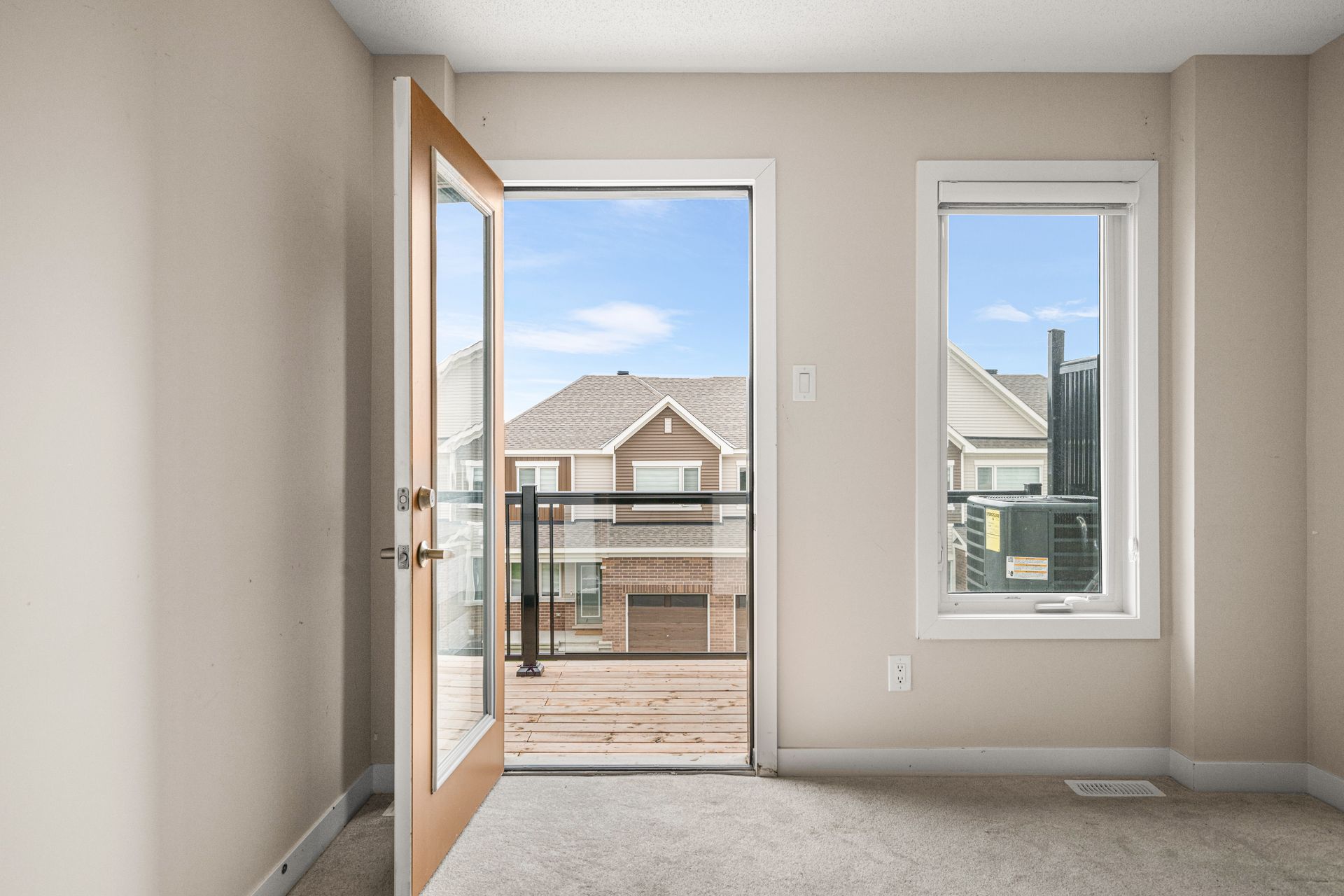 An empty room with a sliding glass door leading to a balcony.