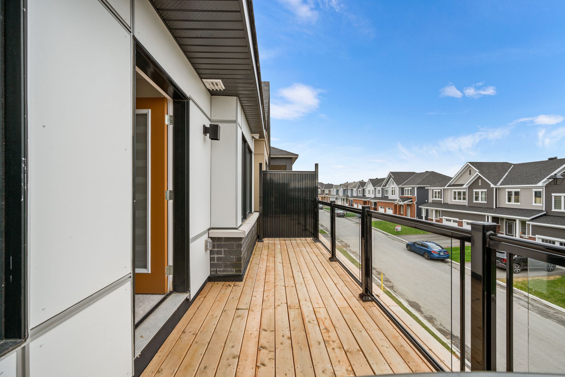 There is a balcony with a view of a row of houses.