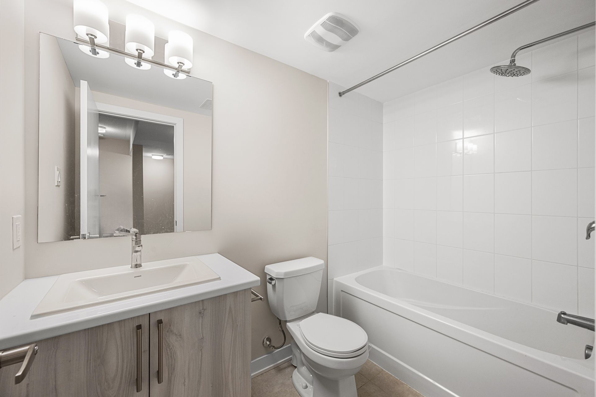 A bathroom with a toilet , sink , bathtub and mirror.