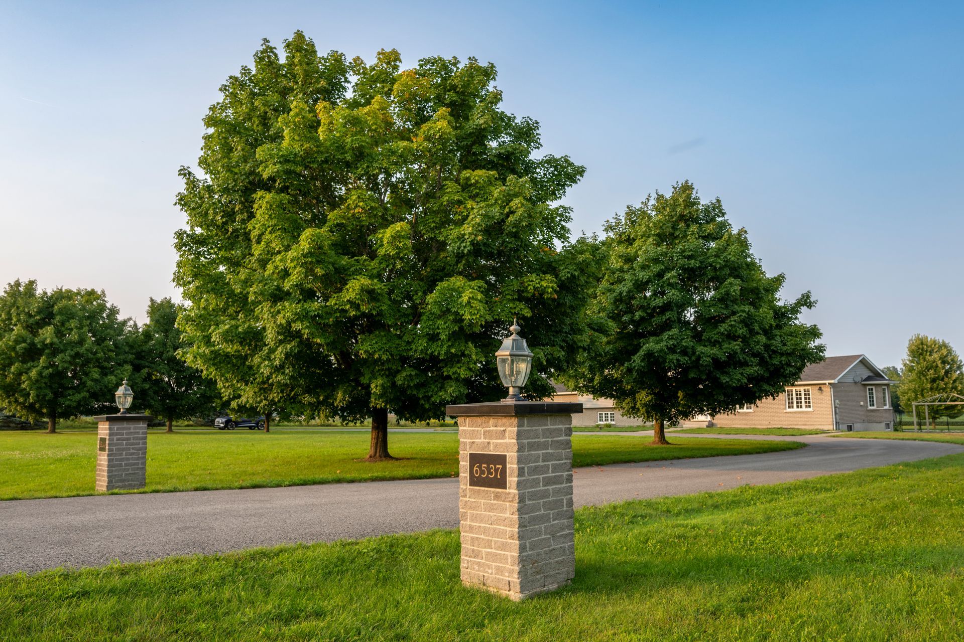 There are two brick pillars in the middle of a grassy field.