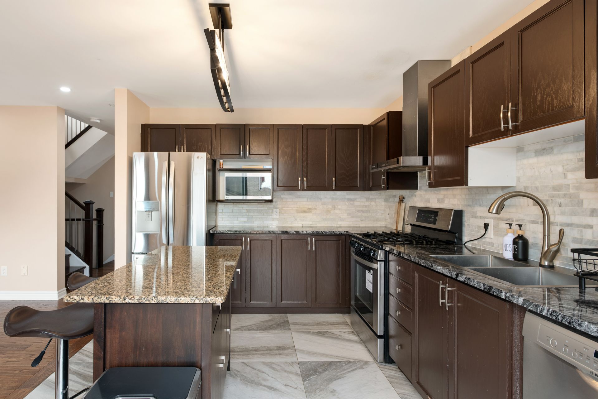 A kitchen with stainless steel appliances and granite counter tops.