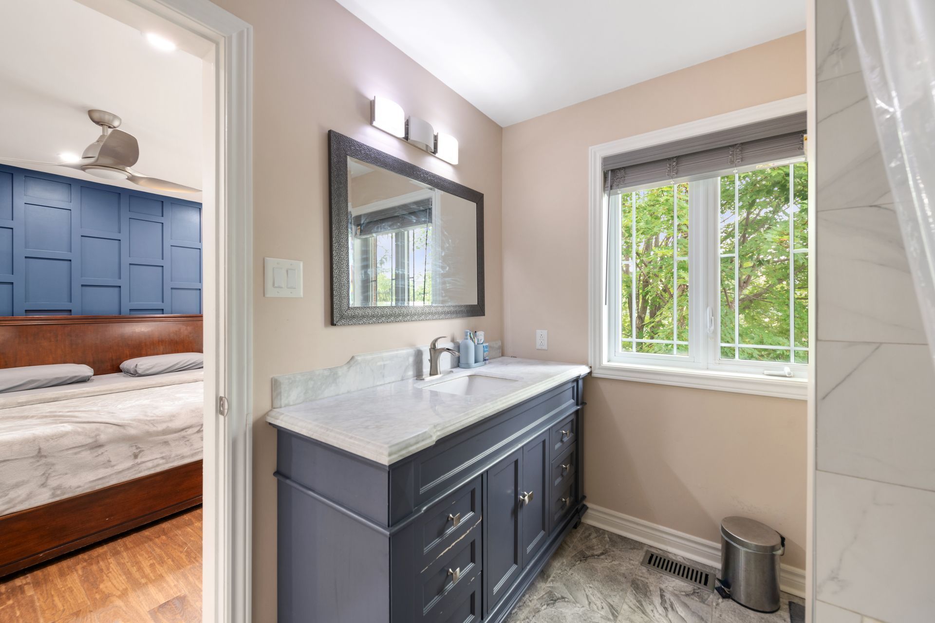 A bathroom with a sink , mirror , and window.