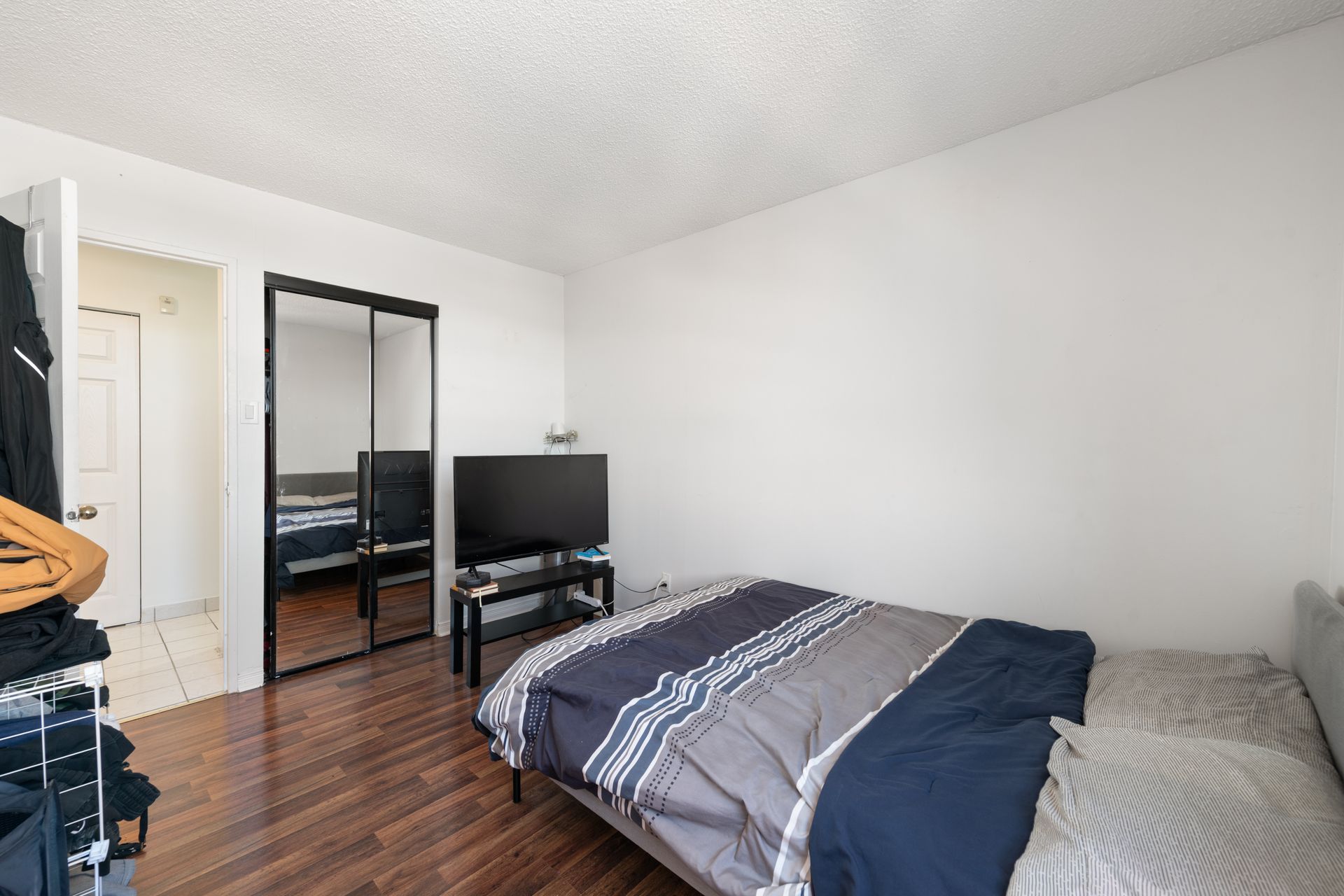 A bedroom with a bed , television , and sliding glass doors.