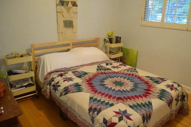 A bedroom with a bed and a quilt on it