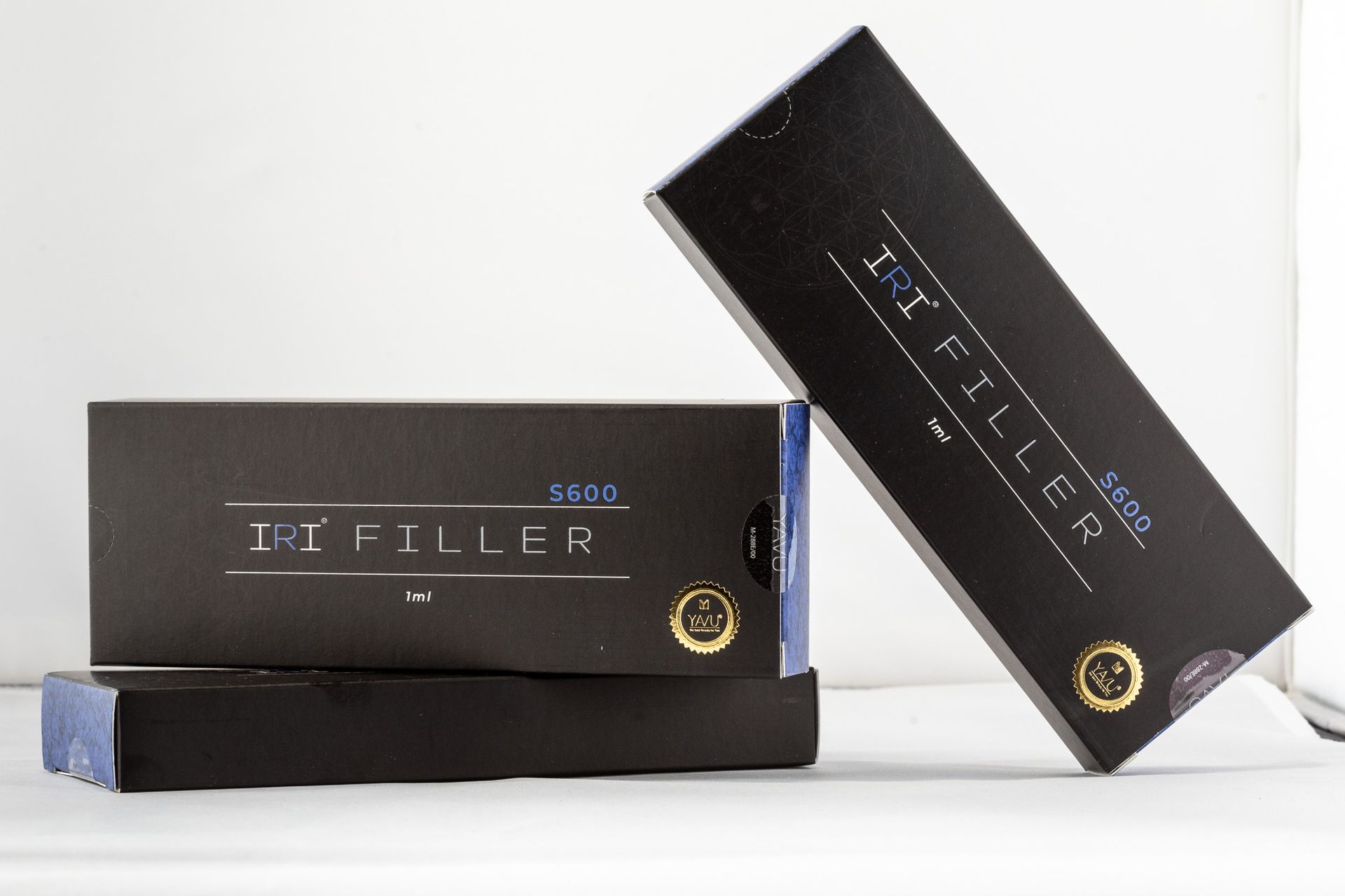 Schwarze und blaue Tri-Filler-Produktverpackungen auf weißem Hintergrund