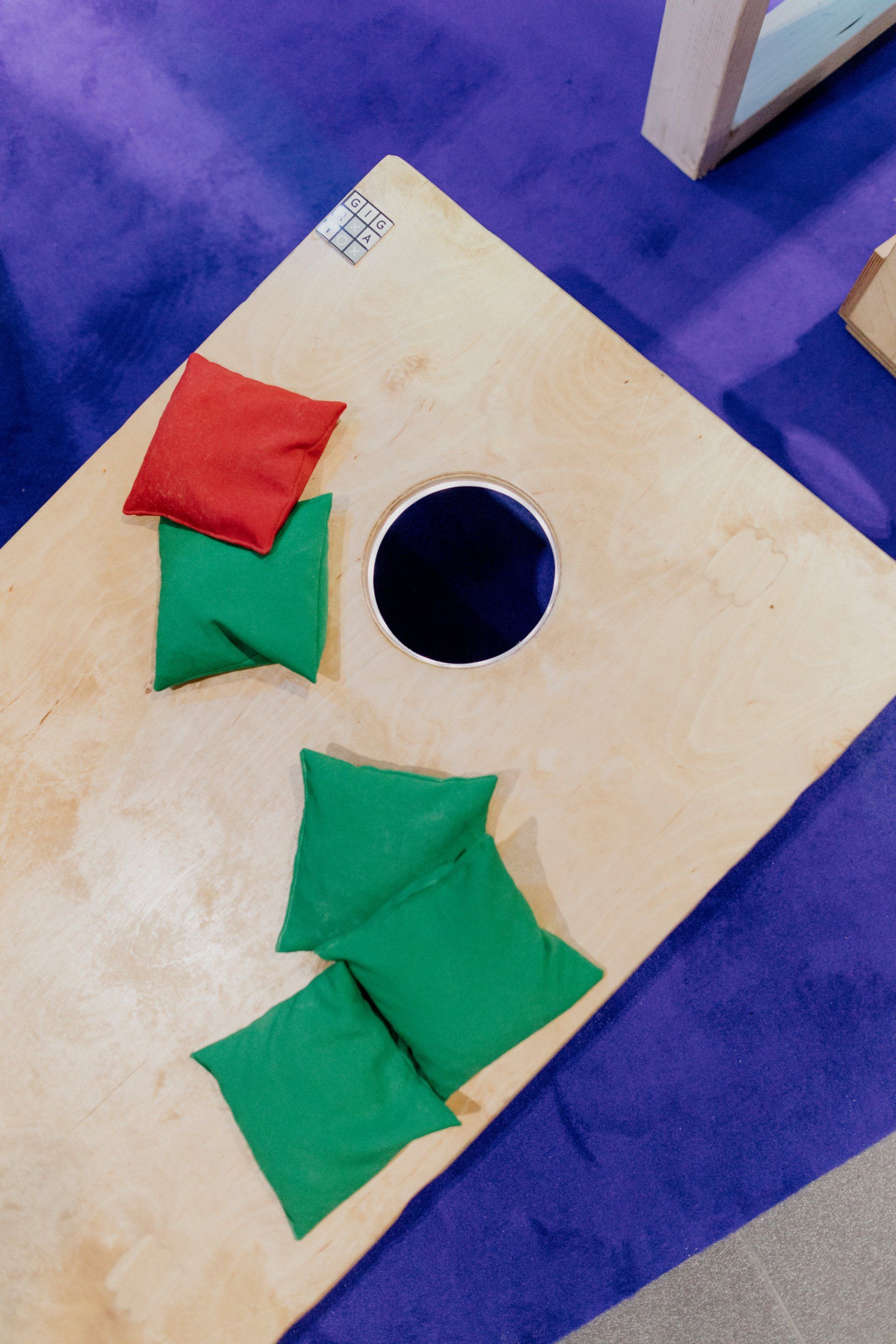 drewniana deska z trzema woreczkami z fasolą i dziurą pośrodku.