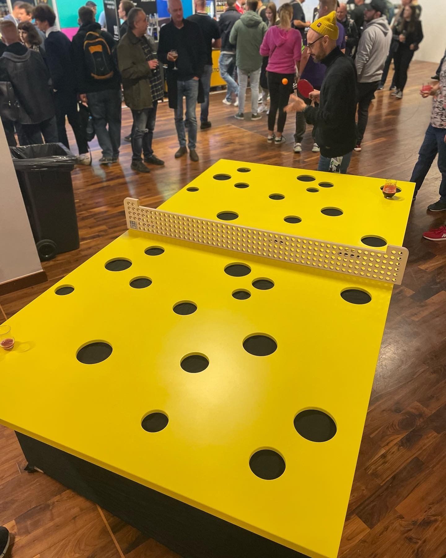 grupa ludzi stoi wokół stołu, który wygląda jak kawałek sera.