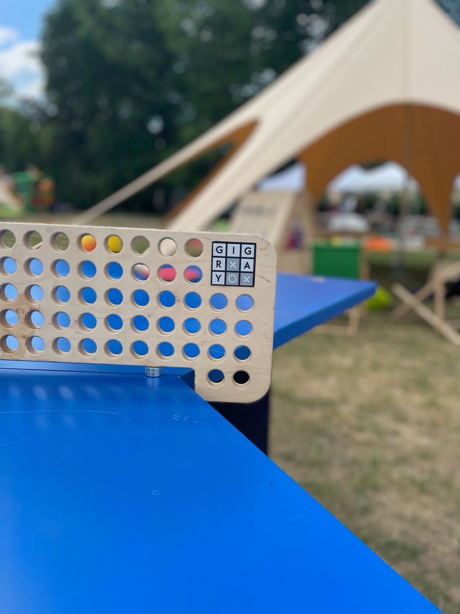 drewniana rakieta do ping-ponga leży na niebieskim stole.