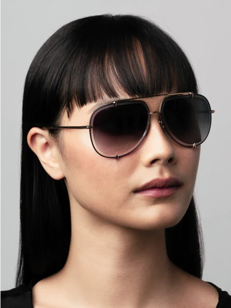 Woman wearing dark aviator sunglasses, with a dark-to-light gradient lens.