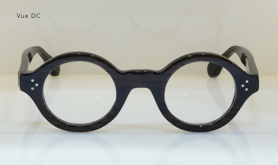 Black round-framed eyeglasses with clear lenses on a white surface.