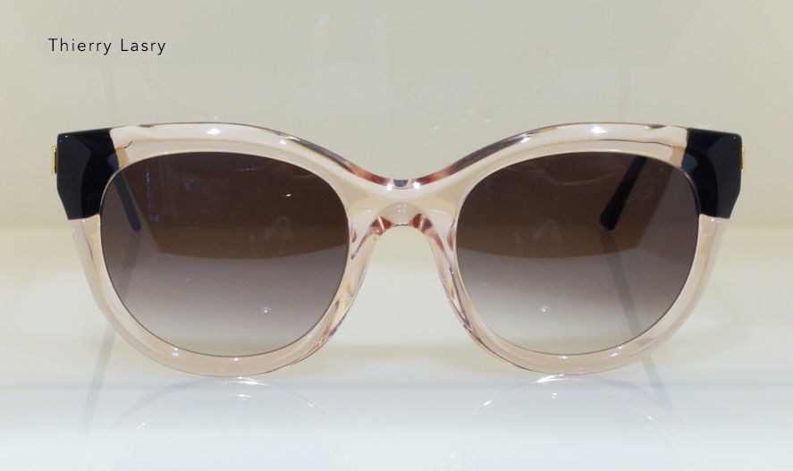 Sunglasses with a light pink frame, dark lenses, and black accents.