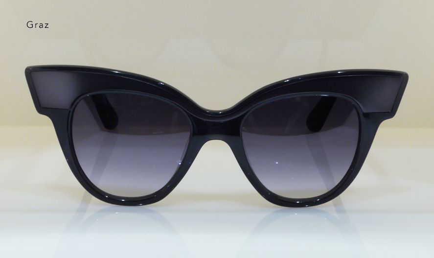 Black cat-eye sunglasses with gradient lenses on a white surface.