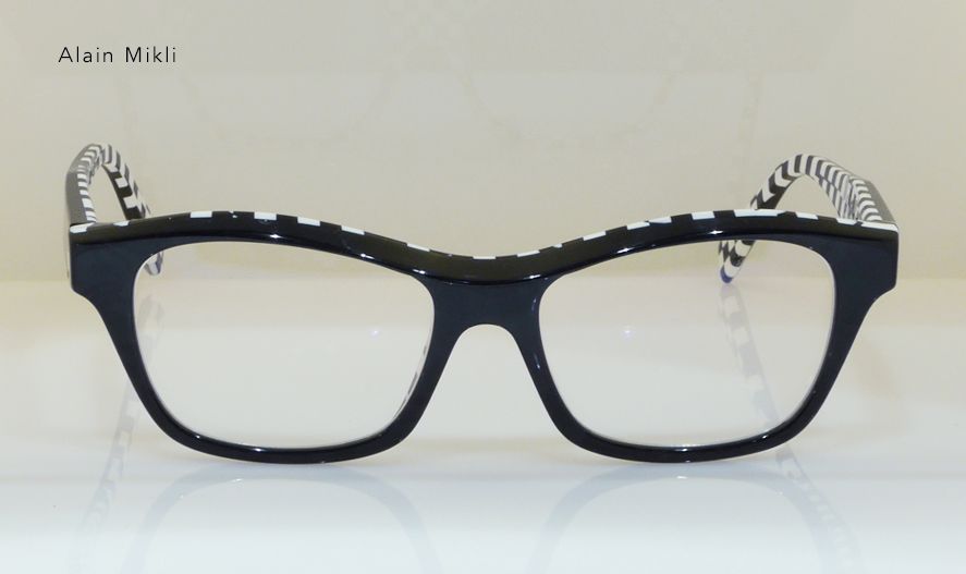 Black and white patterned eyeglasses on a white surface, featuring a unique zebra-striped pattern on the arms.