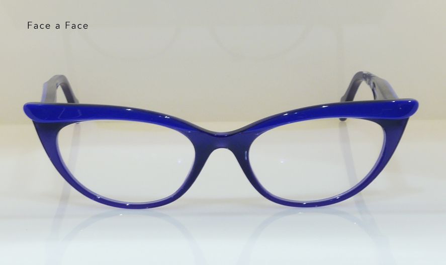 Blue cat-eye eyeglasses with clear lenses on a white surface.