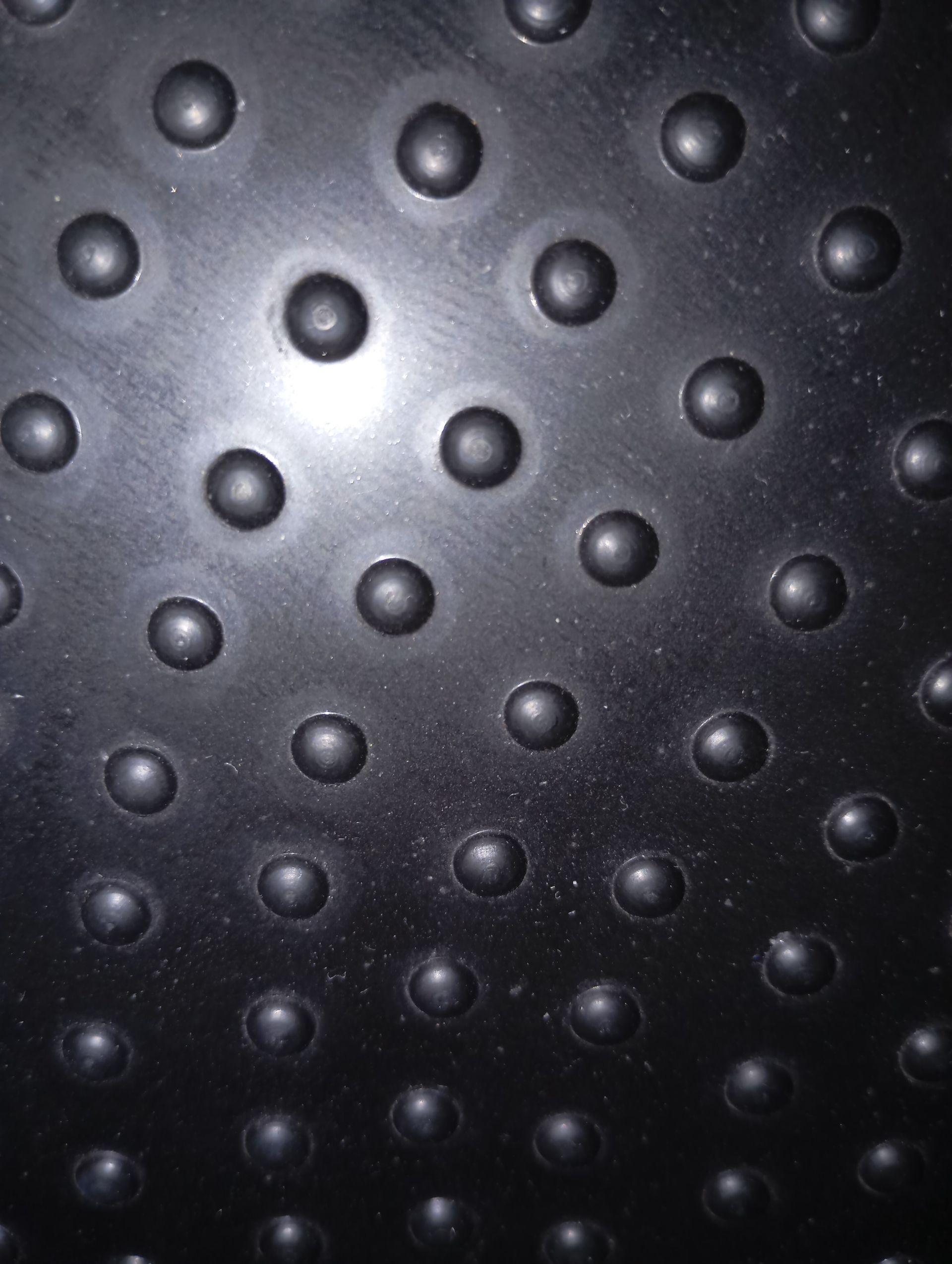 Un primo piano di una superficie nera con dei buchi