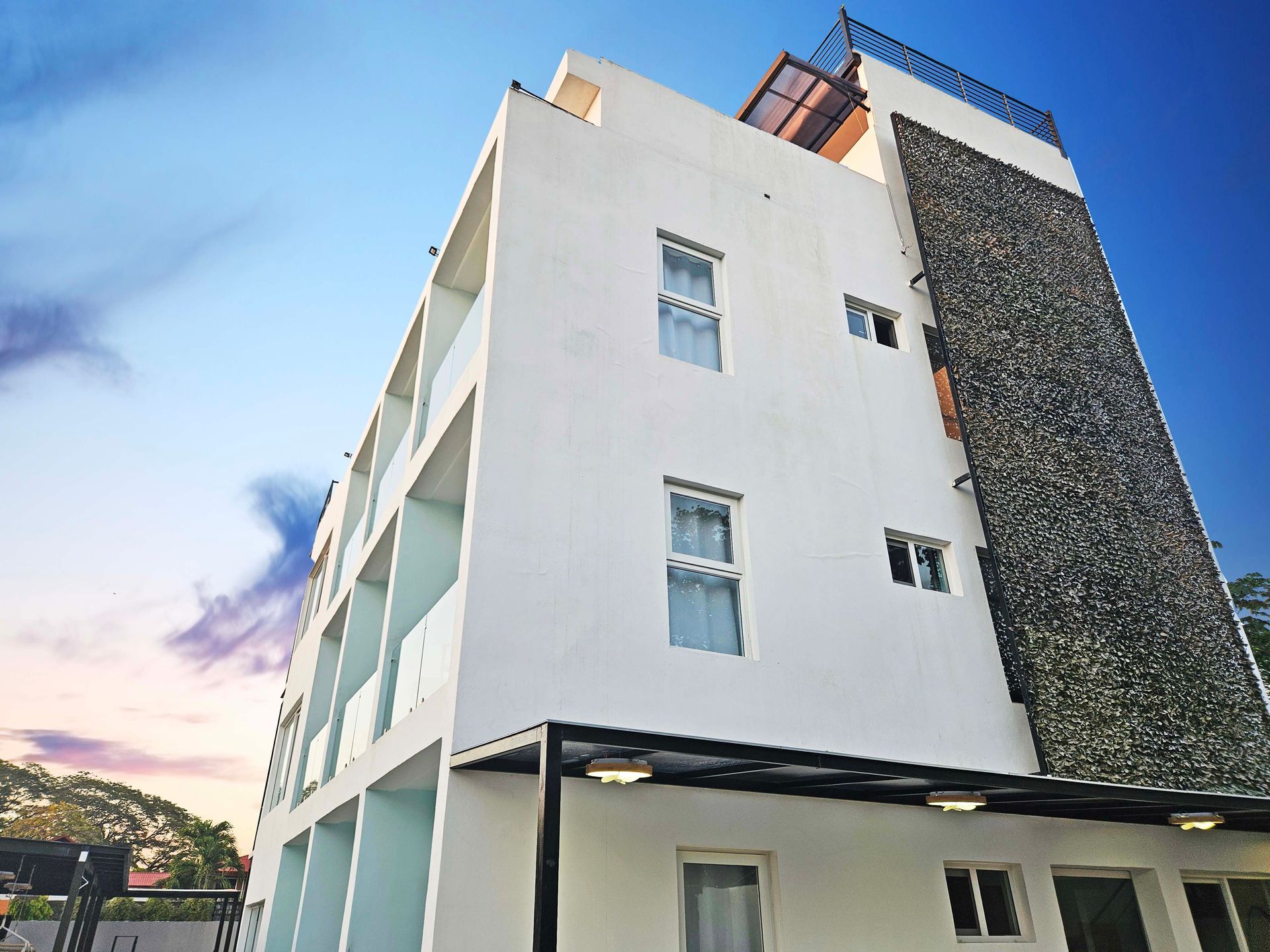 White building with stone accent, blue sky.