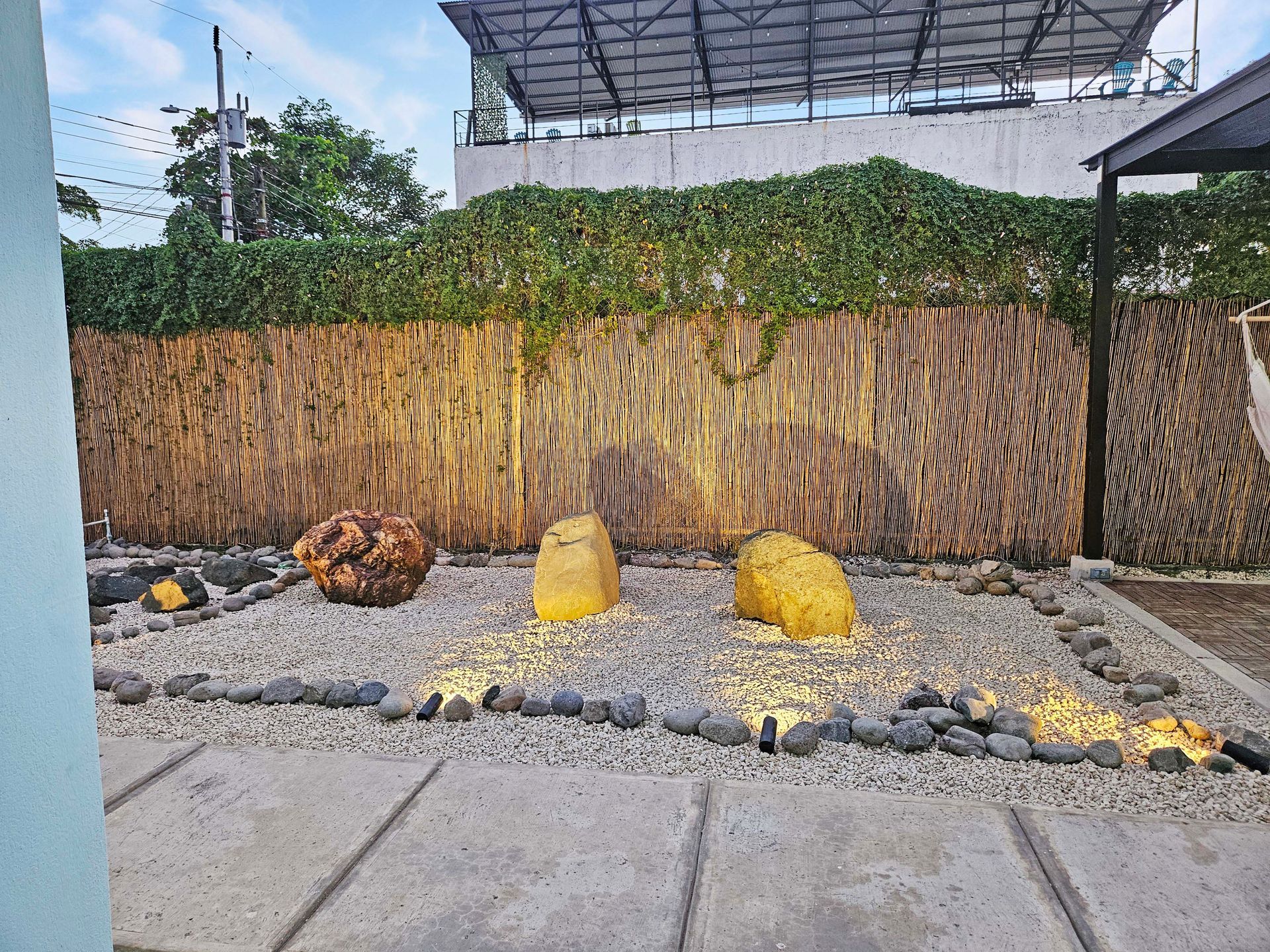 A decorative outdoor area with large, illuminated rocks and a bamboo fence.