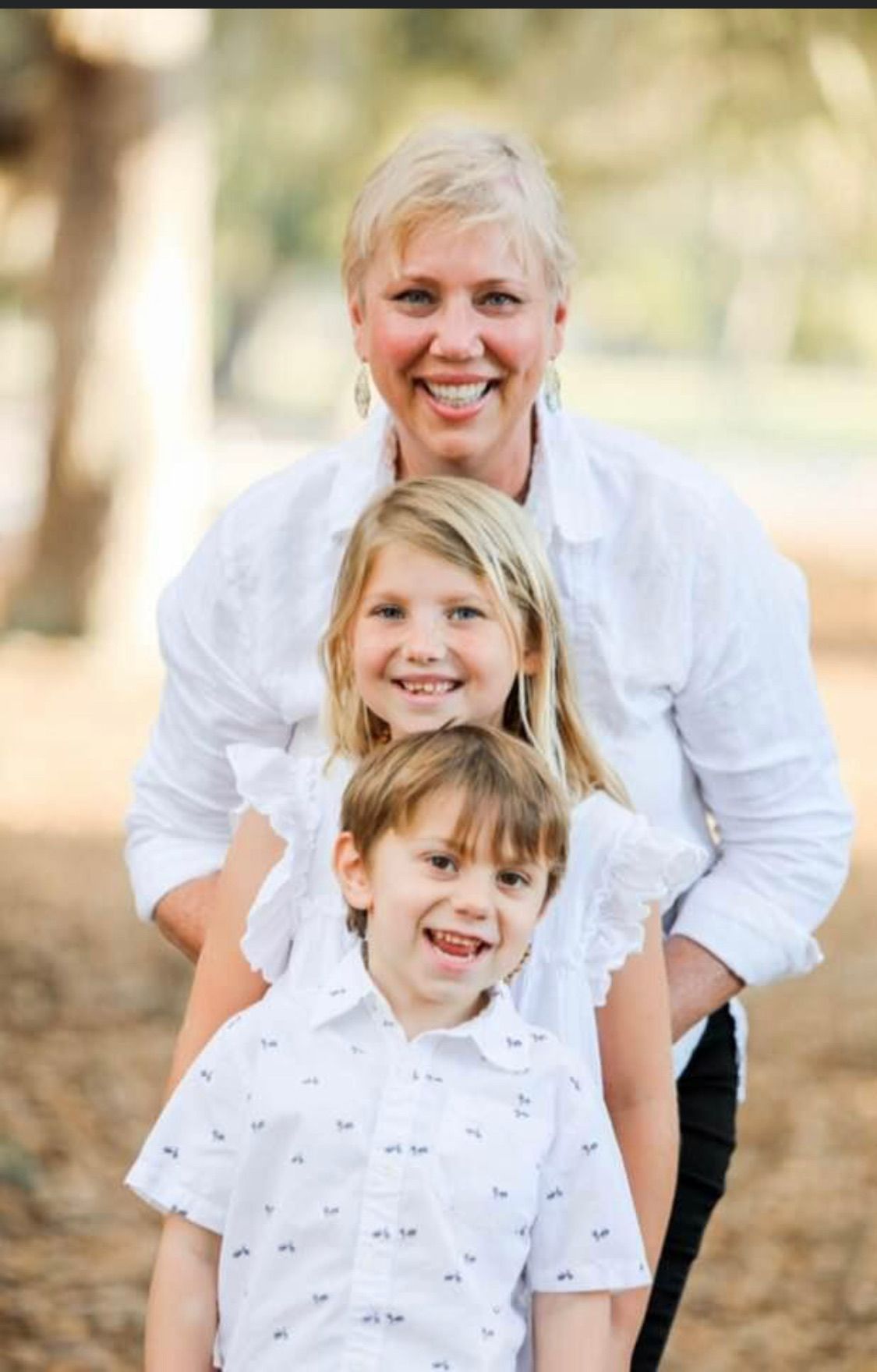 a woman is posing for a picture with two children