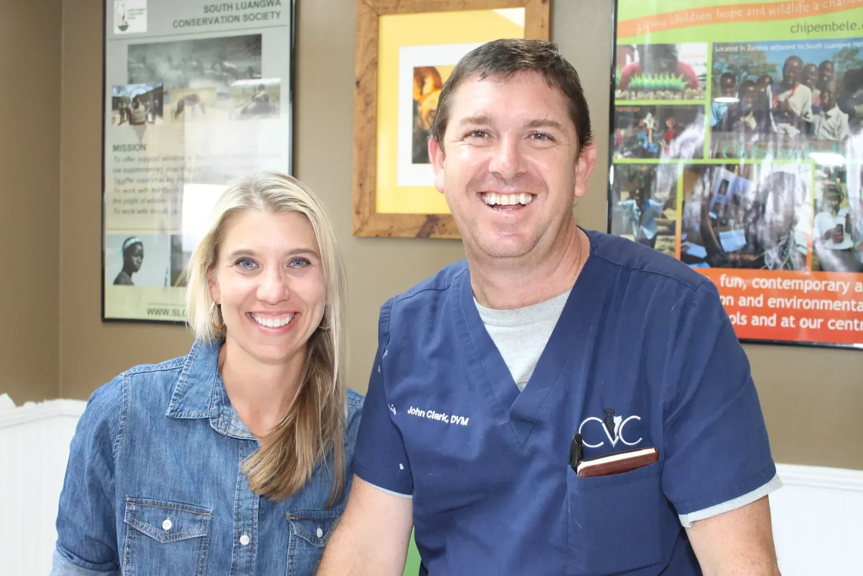 A man and a woman are posing for a picture in a room