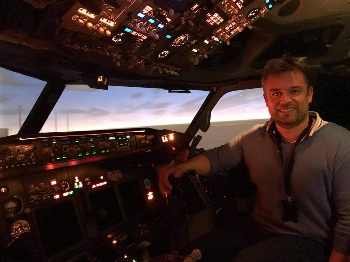 Man ler i flygplanscockpit med upplyst instrumentpanel.
