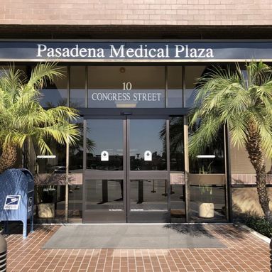 The entrance to pasadena medical plaza is shown with palm trees in front of it.