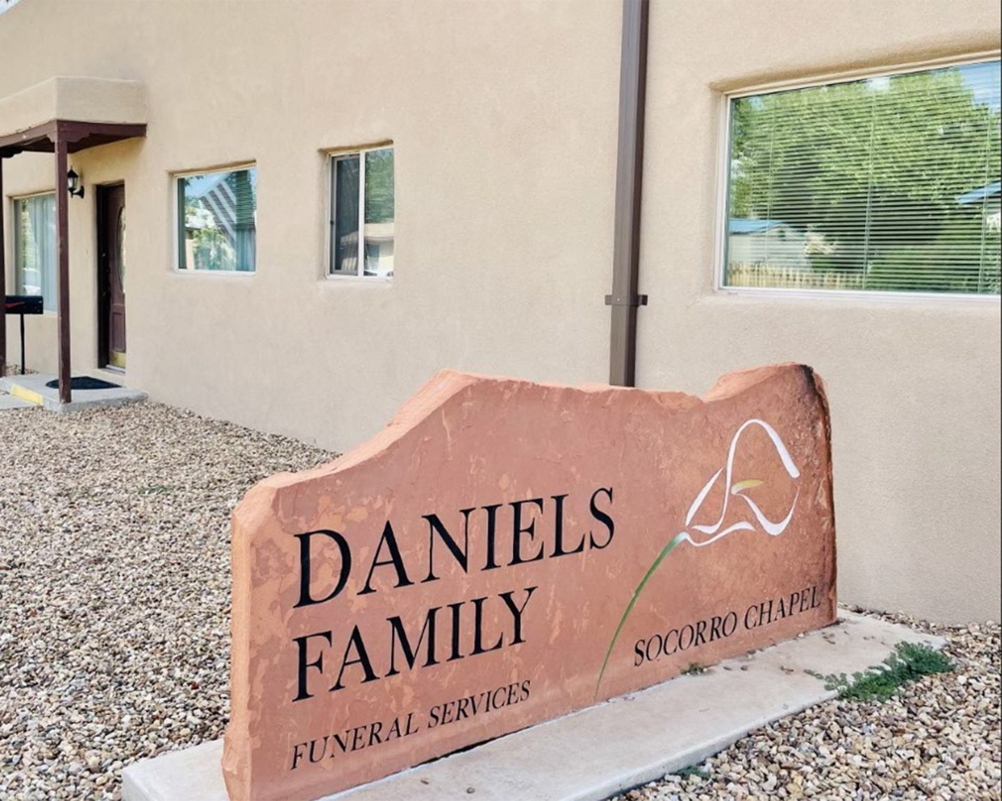 Rendering of a memorial with a central cross and surrounding structures, trees, and sky.