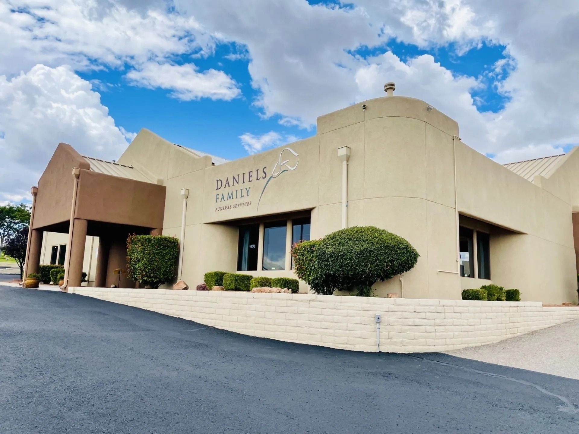 Rendering of a memorial with a central cross and surrounding structures, trees, and sky.