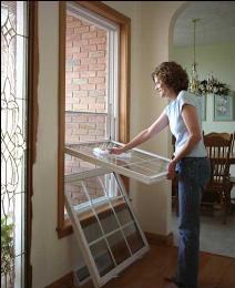 Woman Cleaning the Window — Dover, OH — Wallick's Seamless Spouting LLC