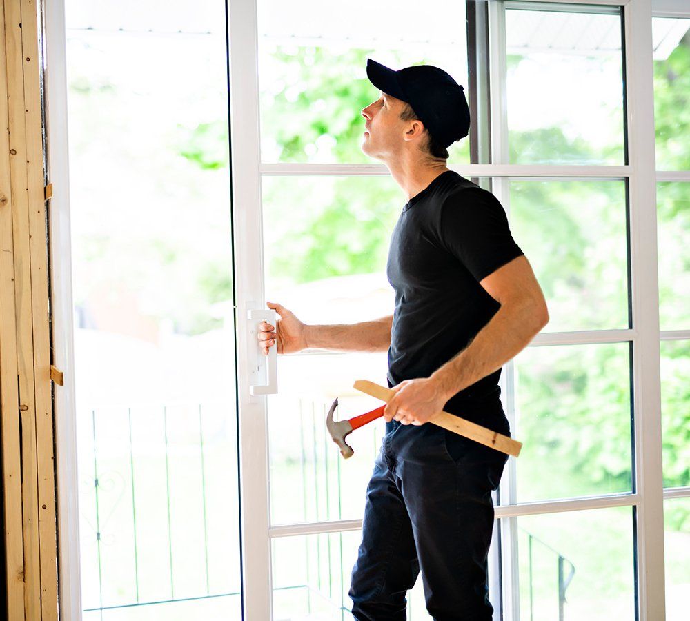 Young Man Installing Double Sliding Patio Door — Dover, OH — Wallick's Seamless Spouting LLC