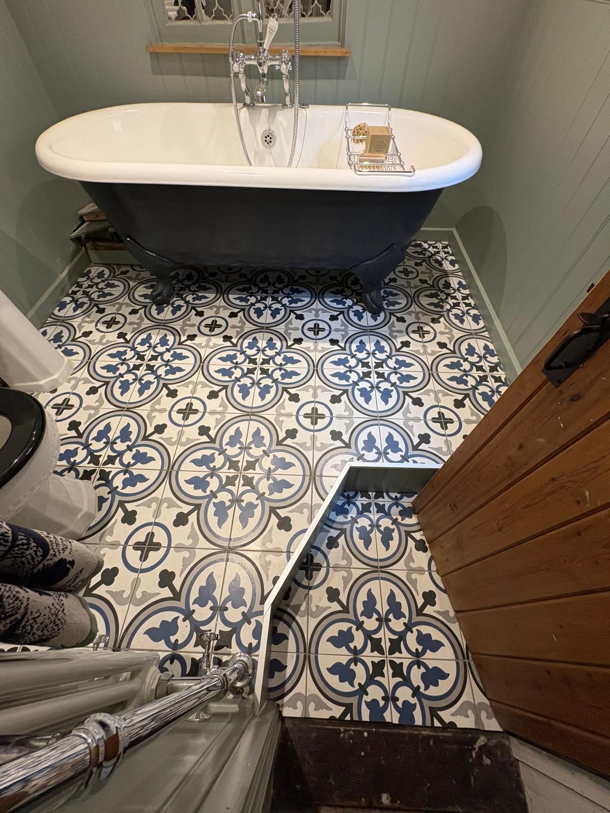 A bathtub is sitting on a tiled floor in a bathroom.