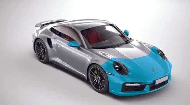 A man in a green shirt is applying a film to the roof of a car.