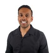 A man in a black shirt is smiling for the camera