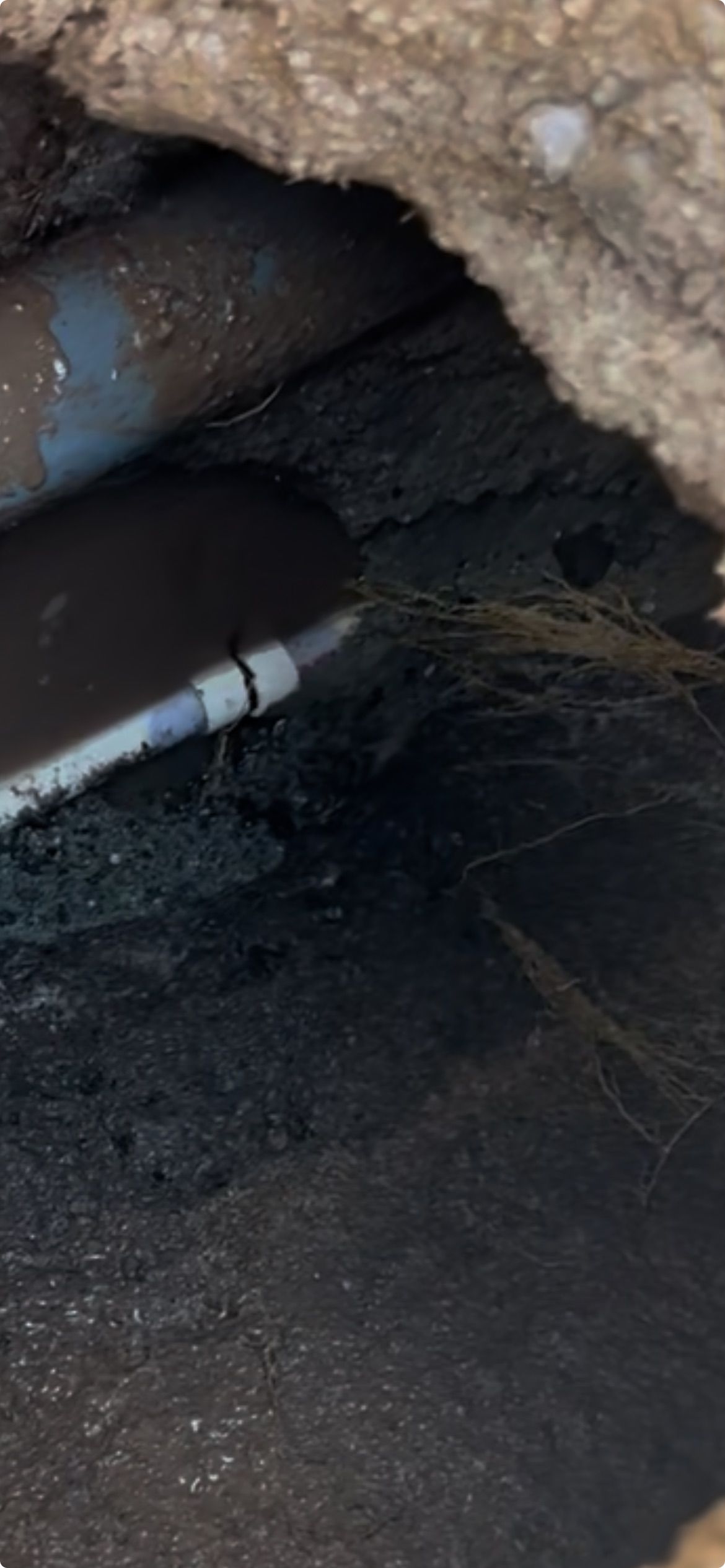 Pipes and insulation in a dark, confined space.