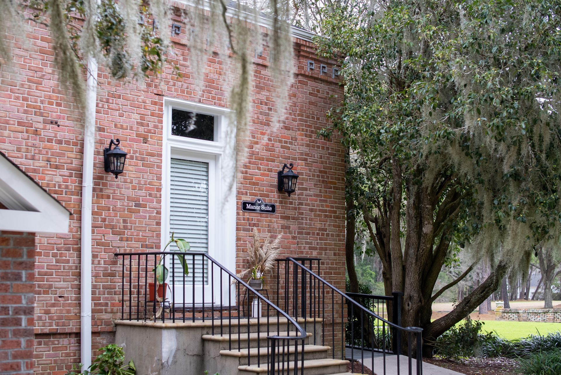 a brick house with stairs leading up to the front door .