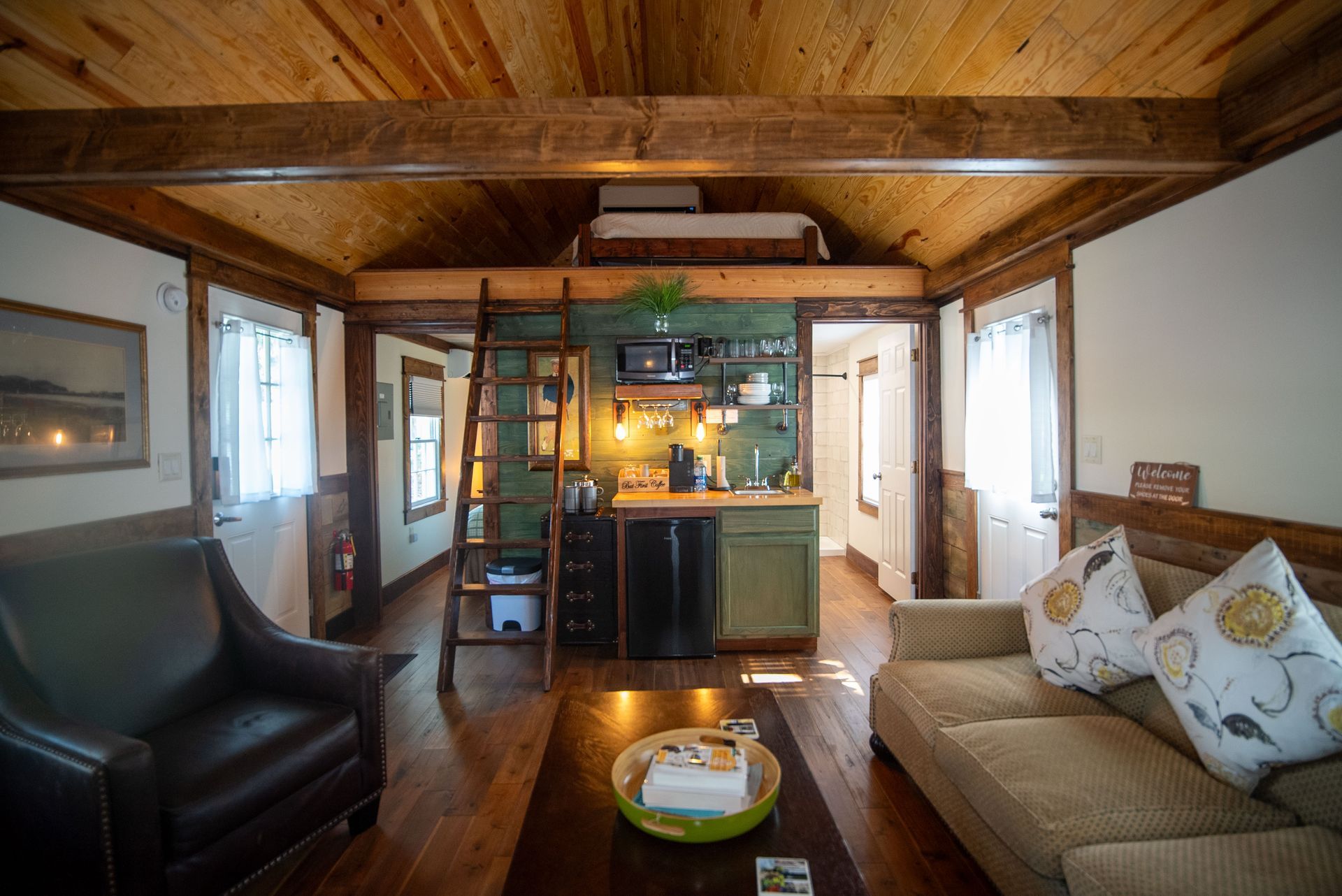 a living room with a couch , chair , coffee table and kitchen .