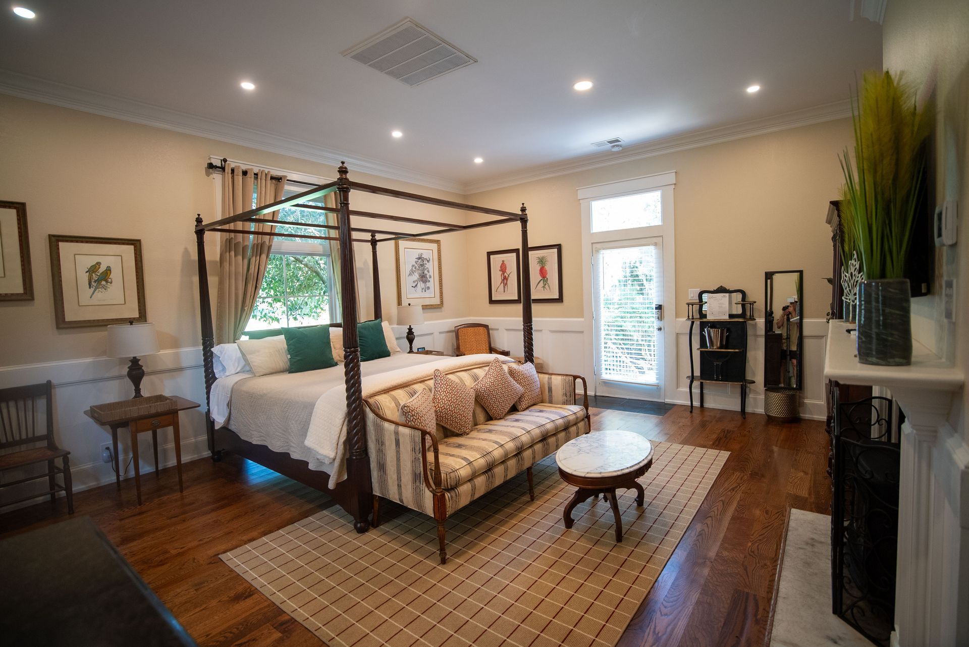 a bedroom with a four poster bed , a couch , and a fireplace .