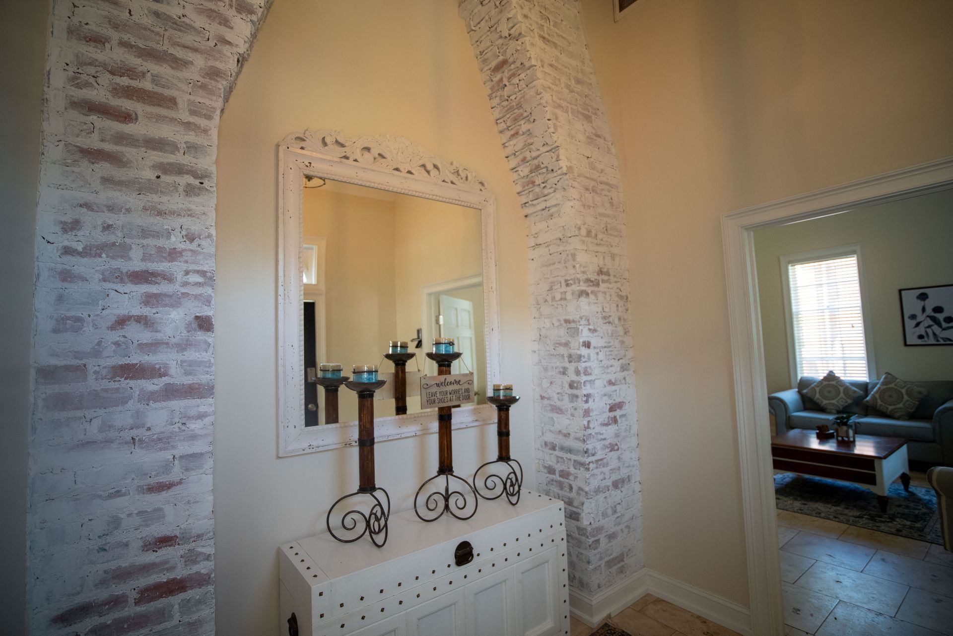 a hallway with a mirror and candles on a table .