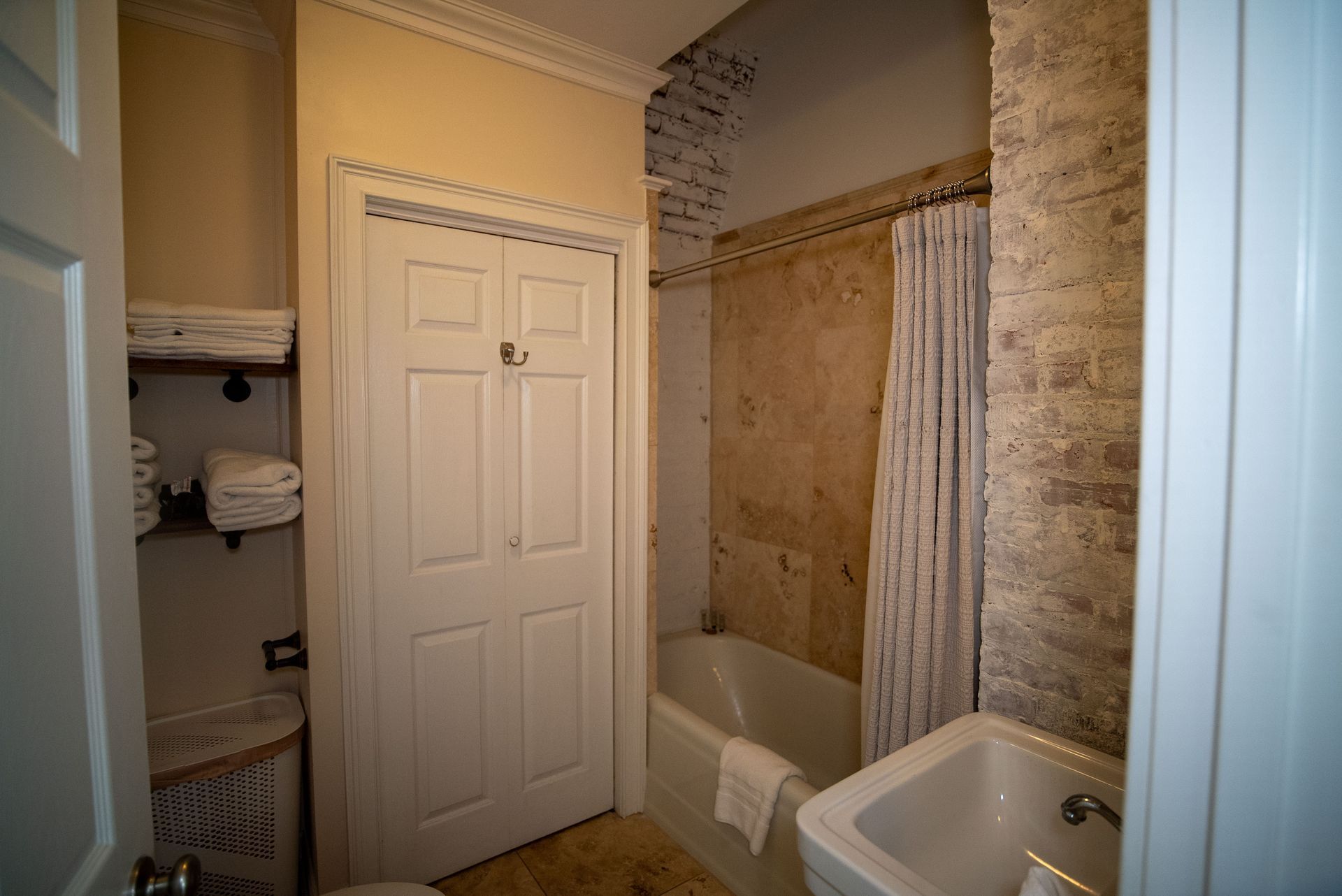 a bathroom with a tub , sink , toilet and door .