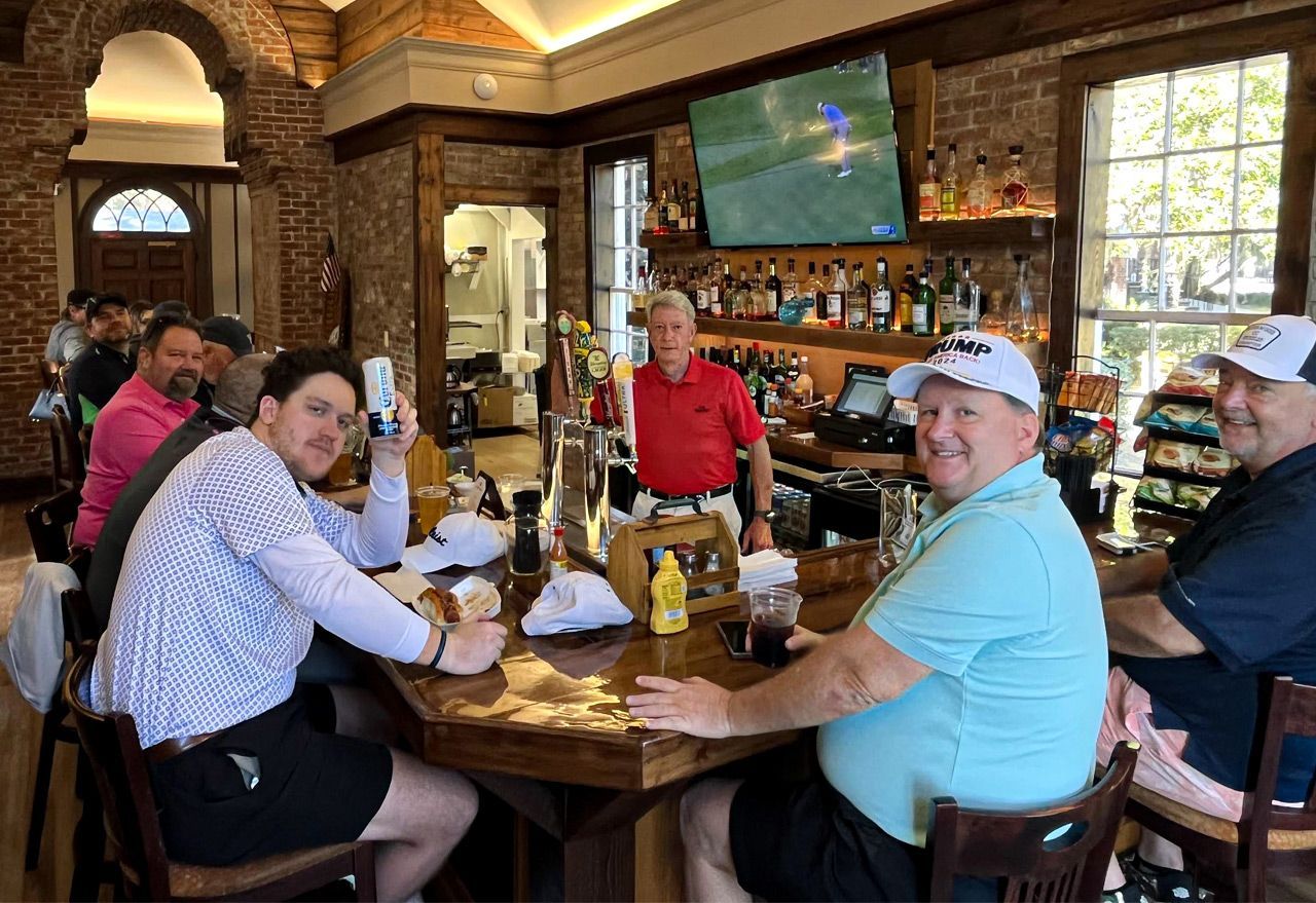 a long wooden bar with stools and a television on the wall .