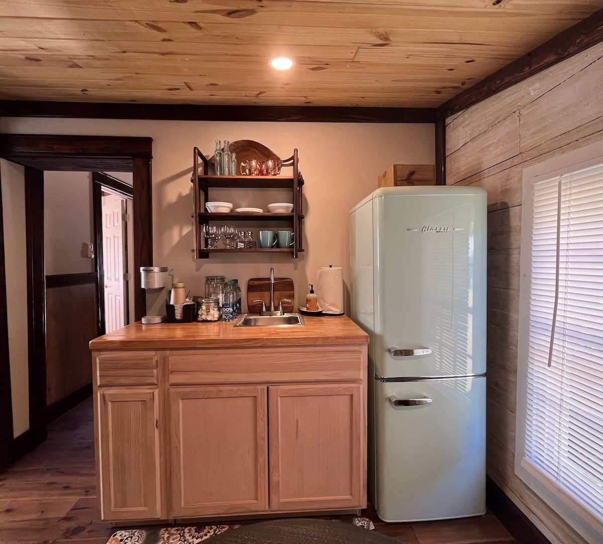 a kitchen with a green fridge and a sink