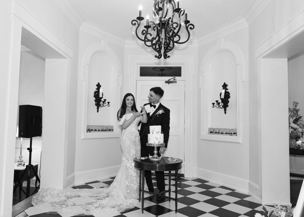 a bride and groom are cutting their wedding cake in a black and white photo .