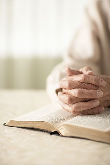 person praying over bible
