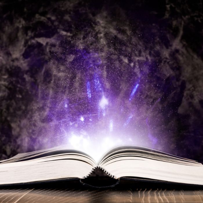 An open book with a purple light coming out of it.