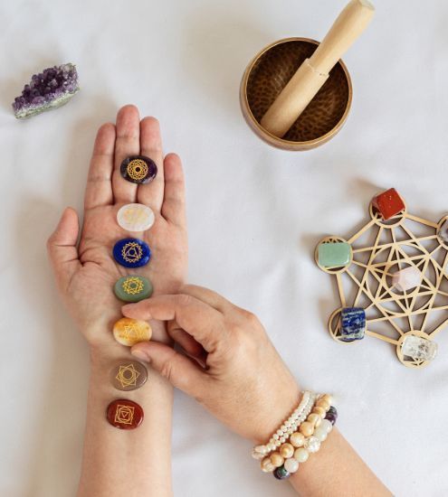 A person is holding a row of chakra stones in their hand.