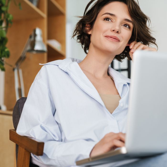 A woman is sitting in front of a laptop computer